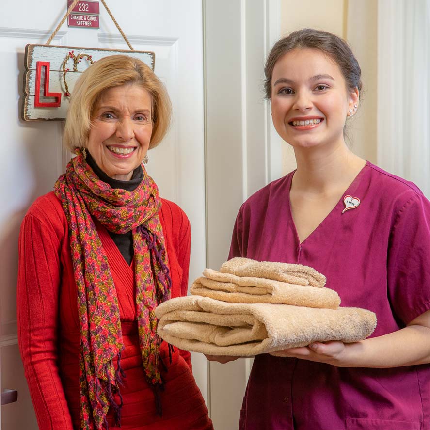 A team member delivering fresh linens to a resident at Springwood Landing